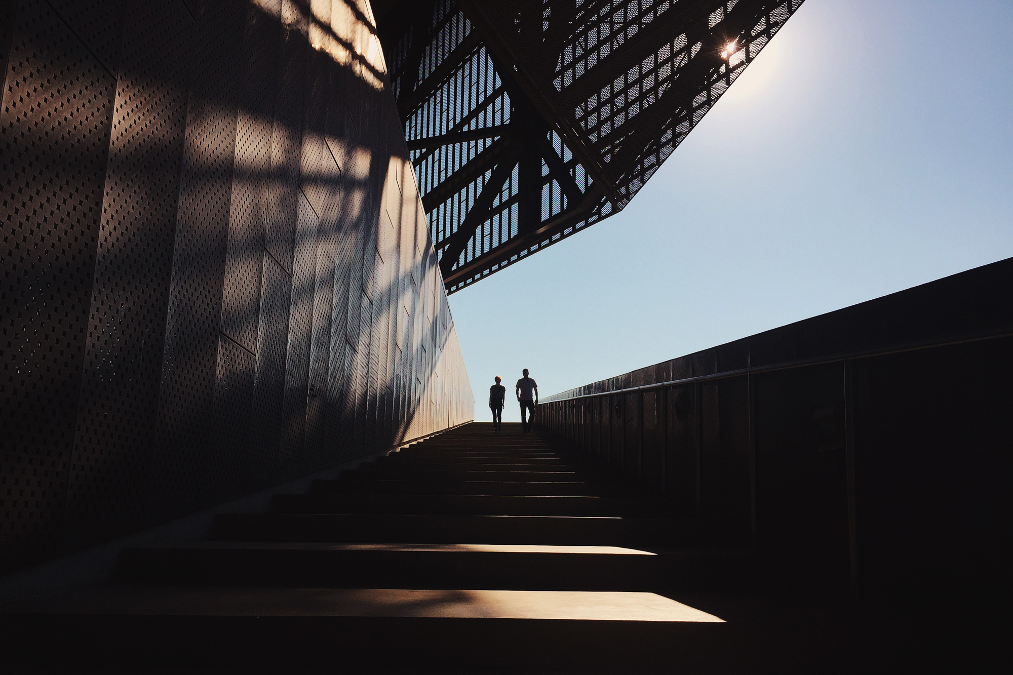 Two people walking up a set of wide and long stairs