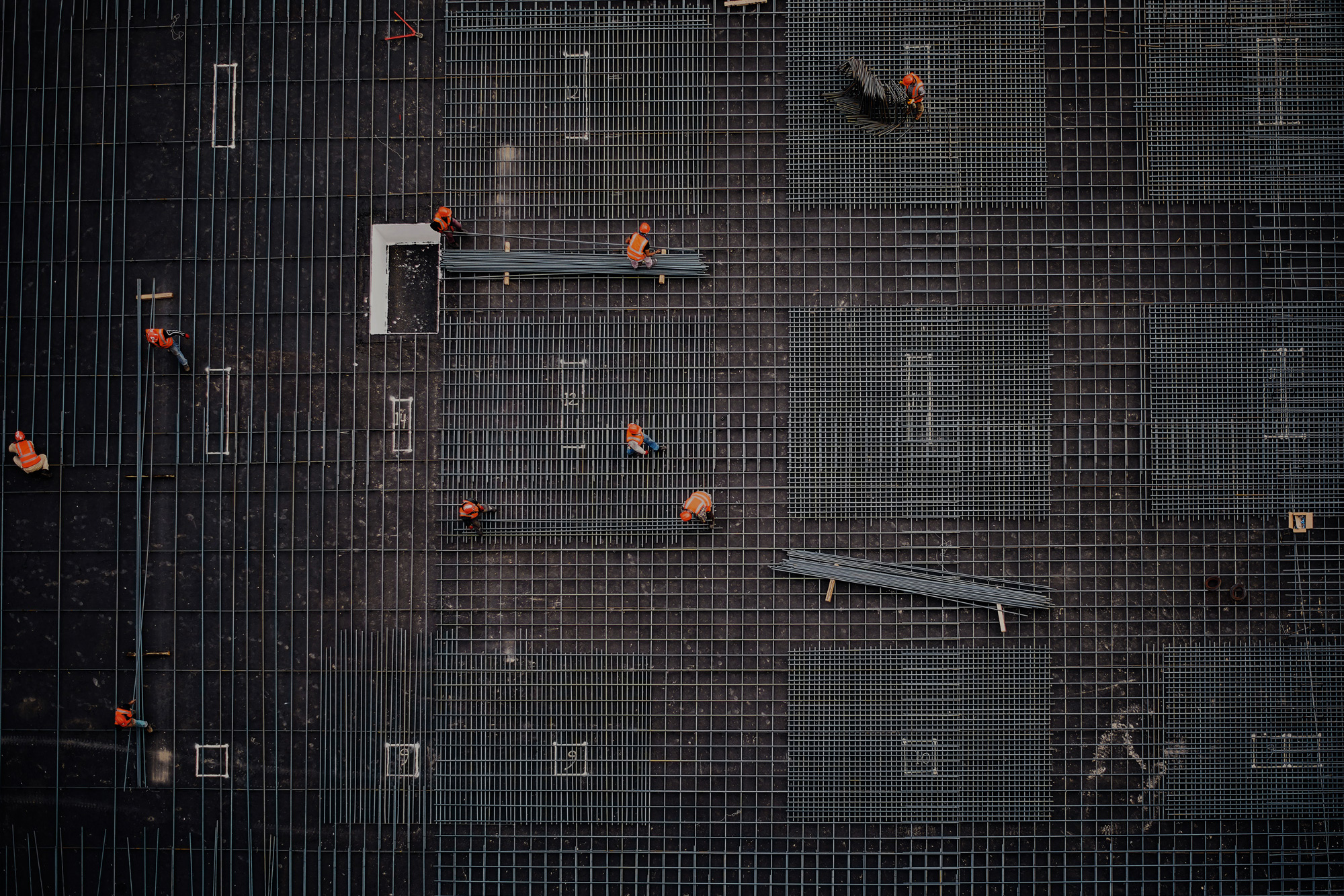 An aerial photo of a construction site with multiple people and steel mesh
