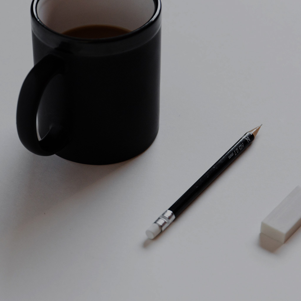 A coffee cup, pencil and eraser on a desk