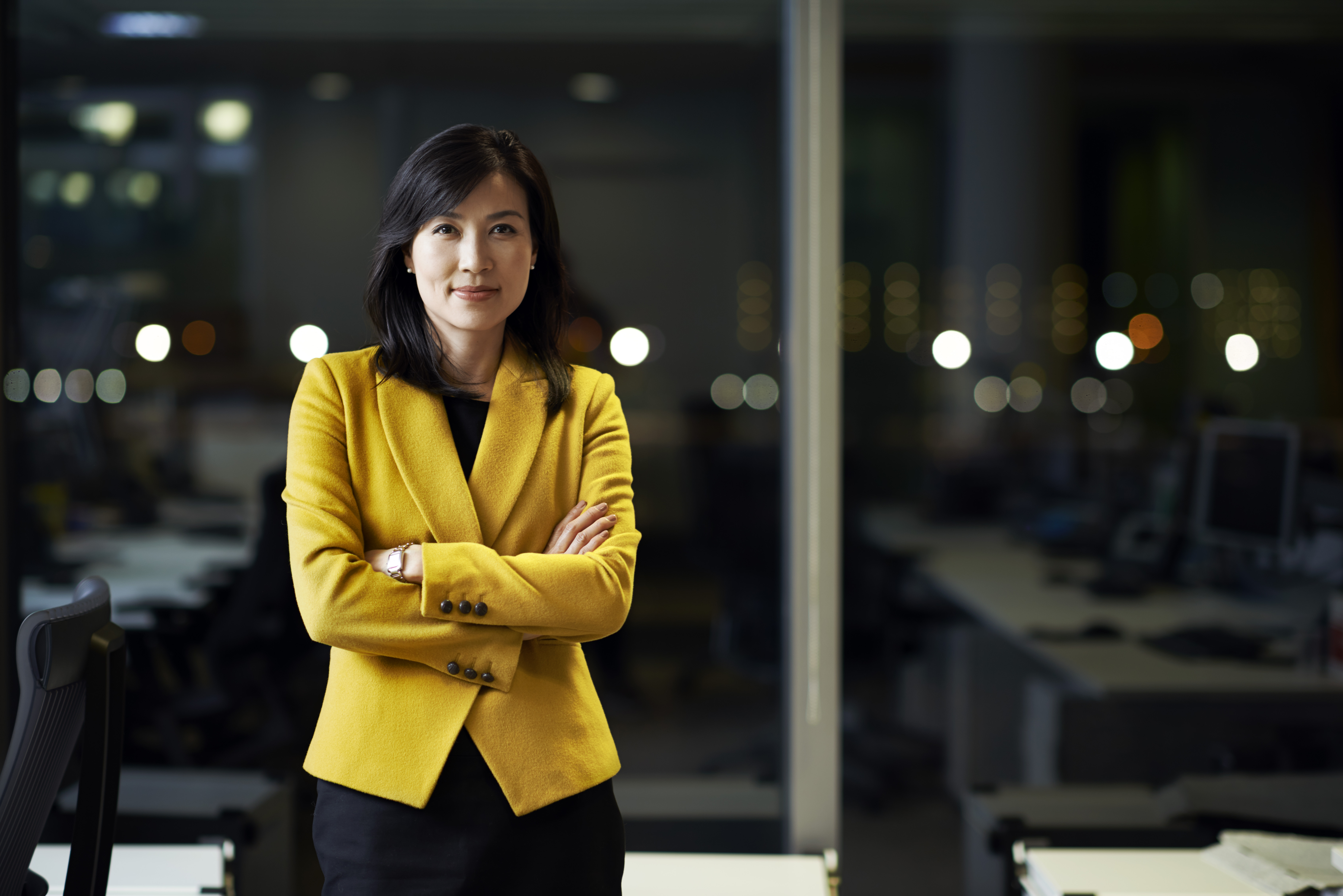 A corporate woman standing in office at night